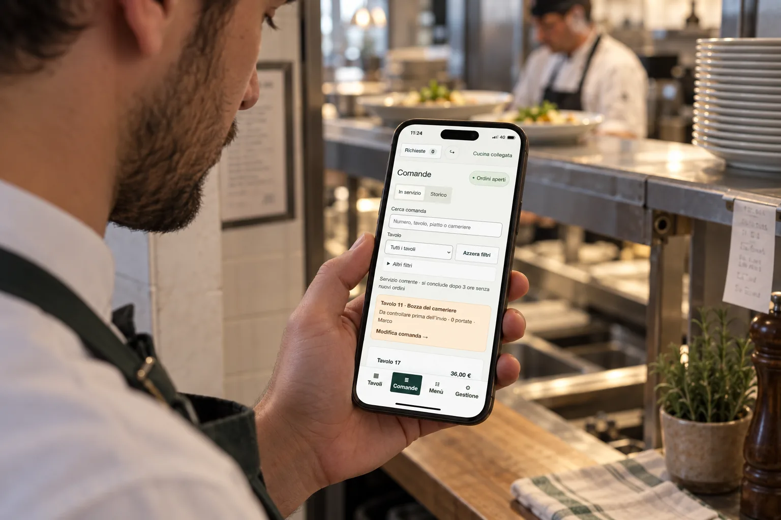 Una cameriera consulta le comande di un tavolo sul telefono