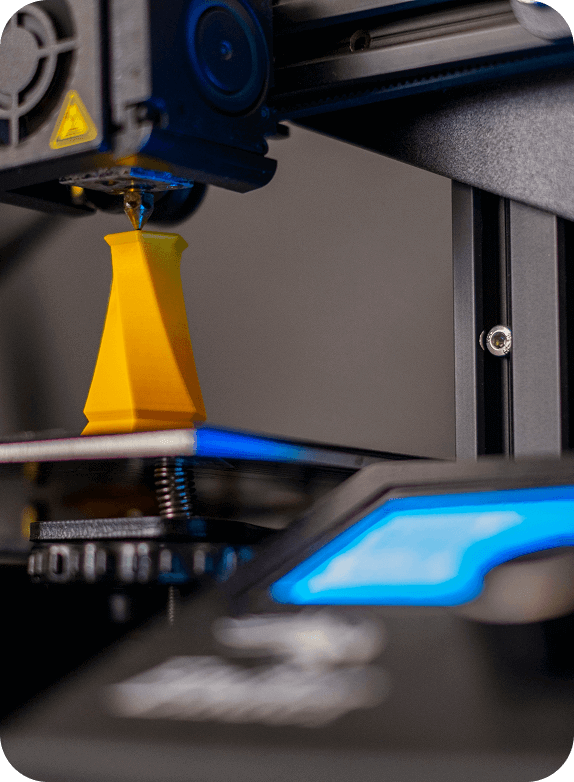 3D printer in operation, producing a yellow precision prototype