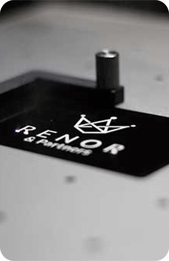 RENOR & Partners logo laser engraved on a professional black metal surface