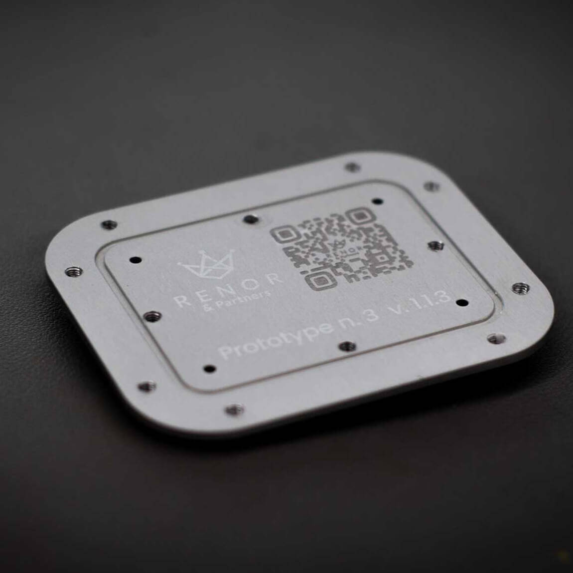 Dettaglio di una placca metallica con logo e QR code incisi permanentemente tramite laser