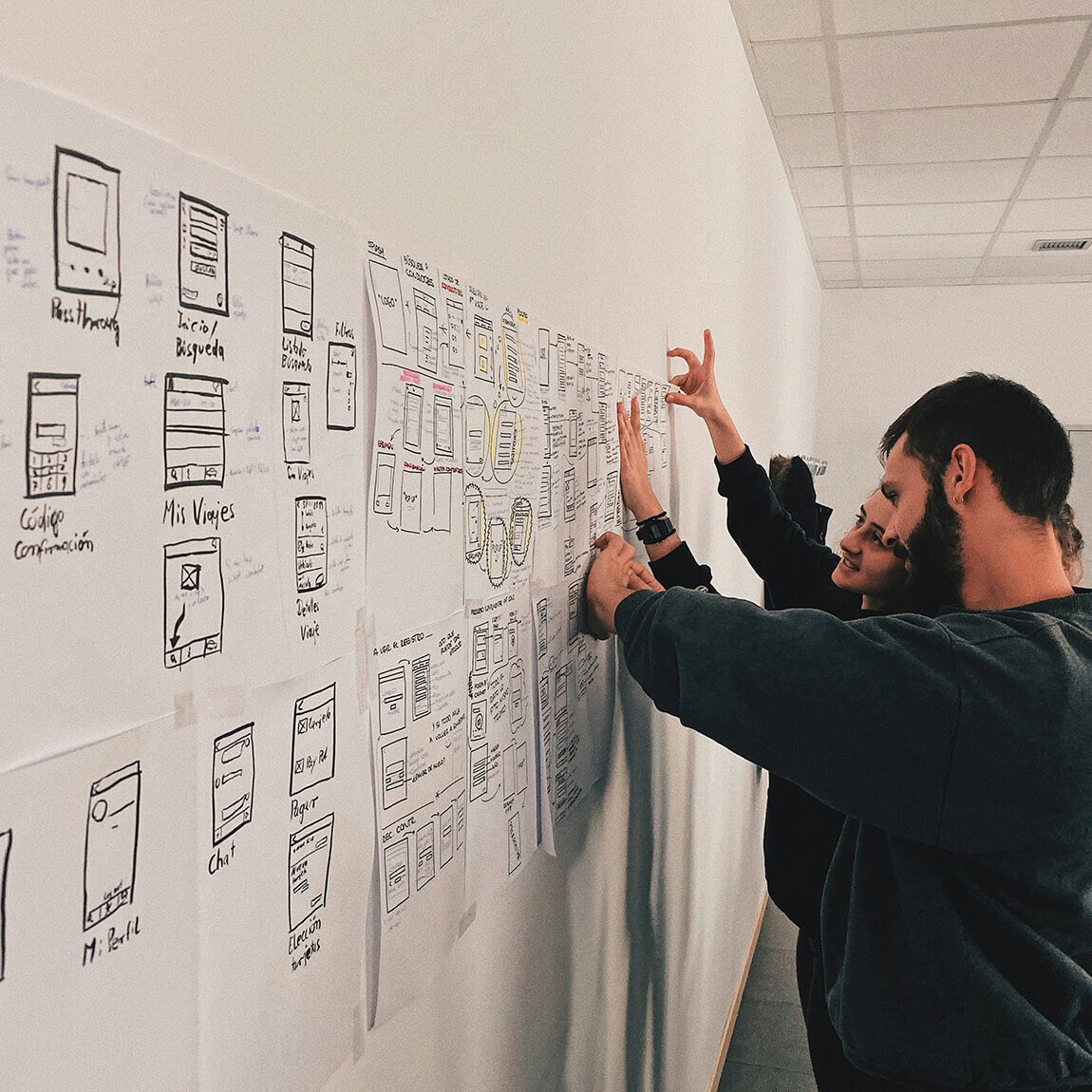 Team di ricercatori che analizza e organizza schemi tecnici complessi su una parete operativa
