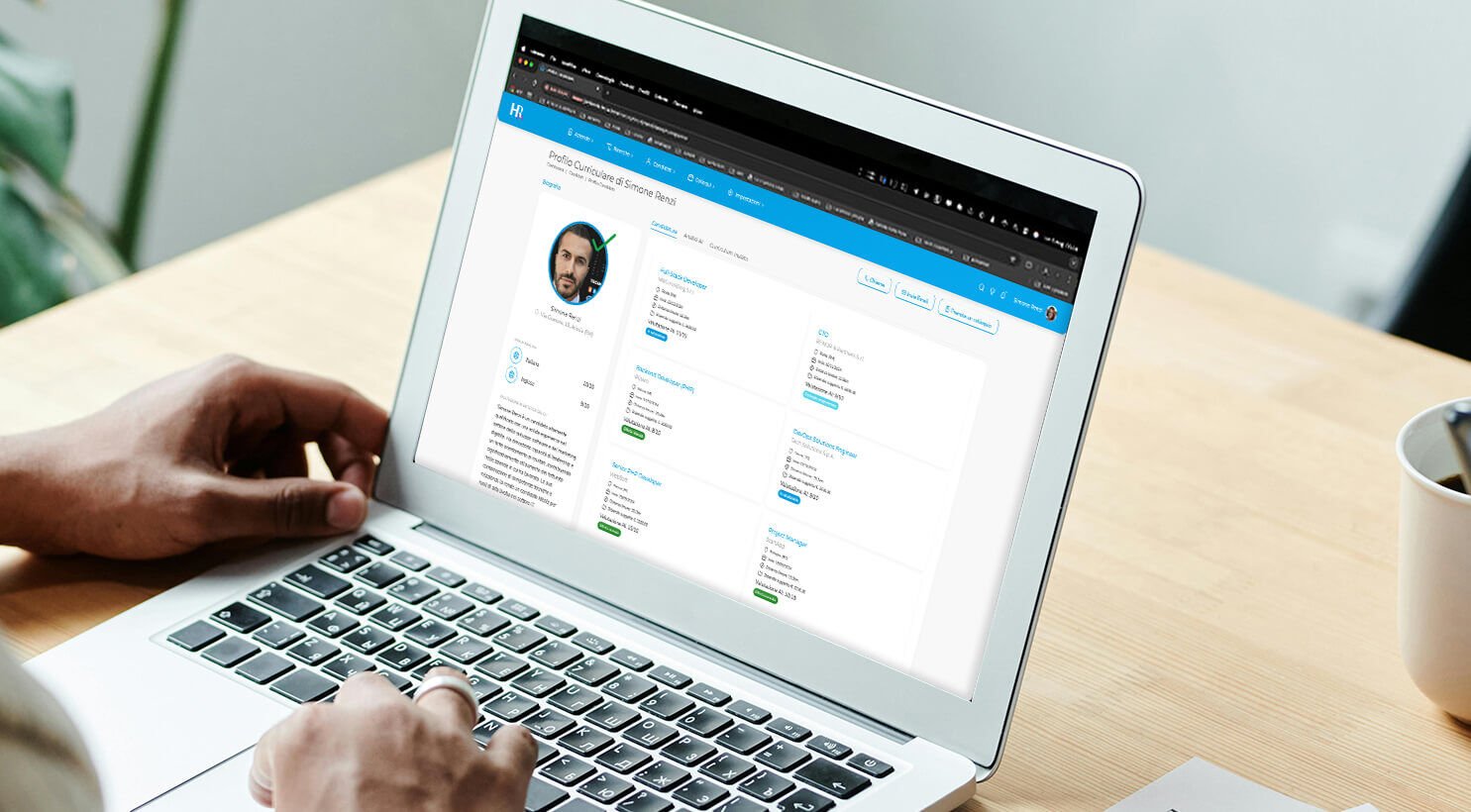 Laptop che mostra la dashboard del software di recruiting con profili di candidati e statistiche
